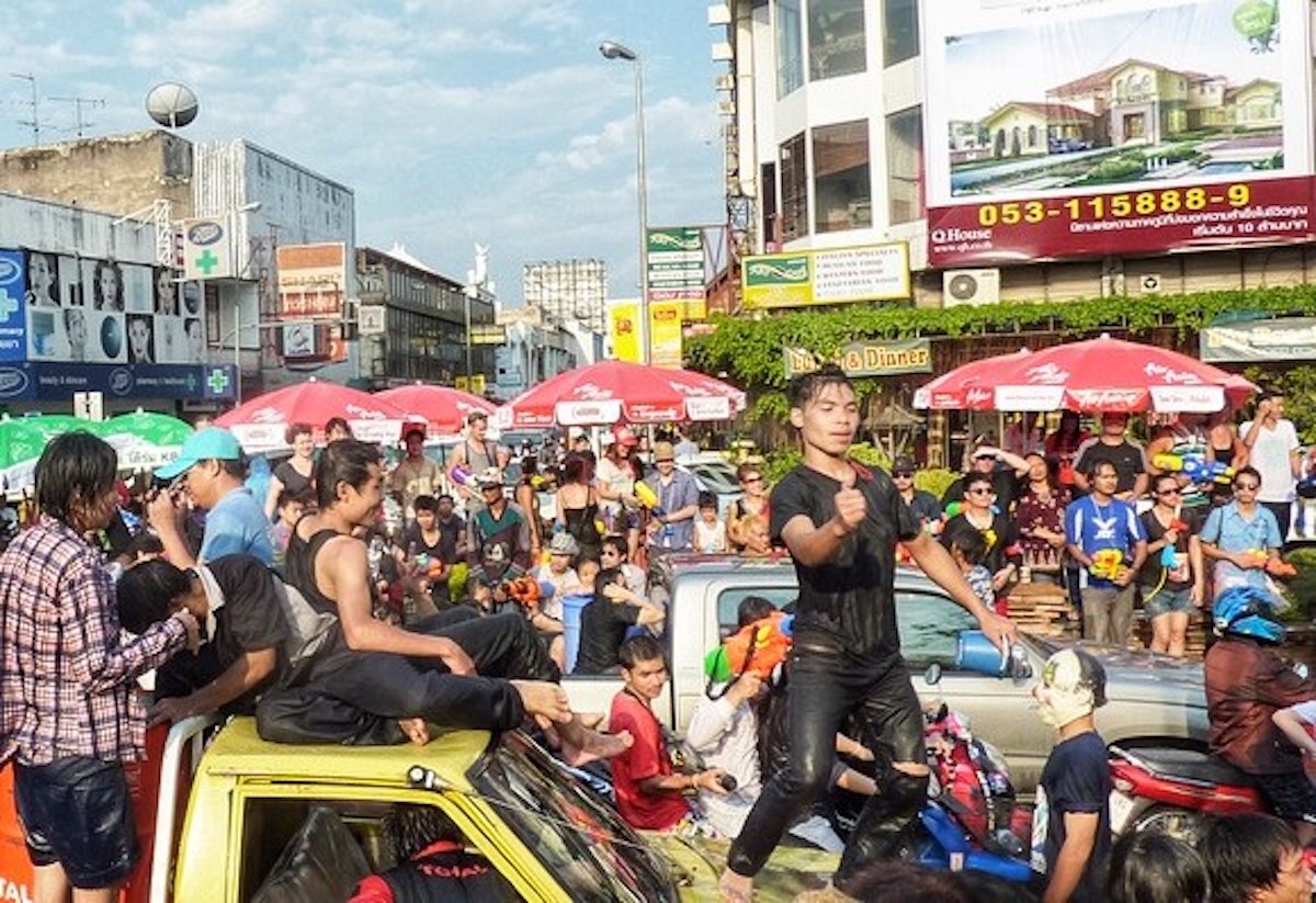 Songkran in Chiang Mai: 2024 Guide To Thailand's Water Festival! | party songkran in chiang mai A young boy dances on a car in a packed crowd.