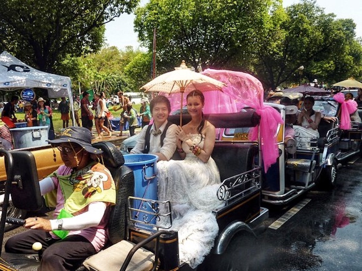 Songkran in Chiang Mai: 2024 Guide To Thailand's Water Festival! | religious procession songkran chiang mai A boy and girl smile at a religious ceremony in Thailand.