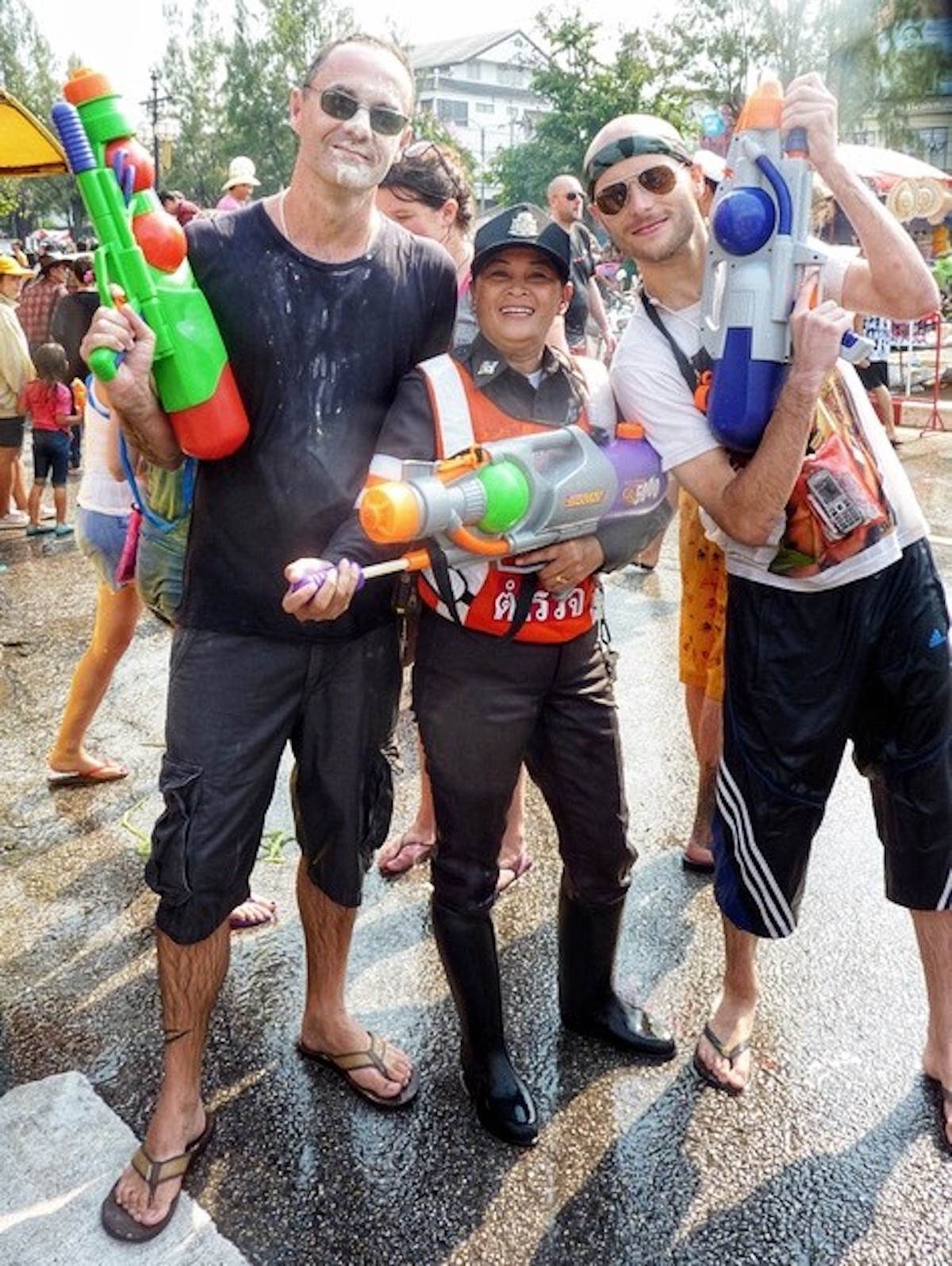Songkran in Chiang Mai: 2024 Guide To Thailand's Water Festival! | songkran celebrations chiang mai A policewoman poses with tourists in Thailand.