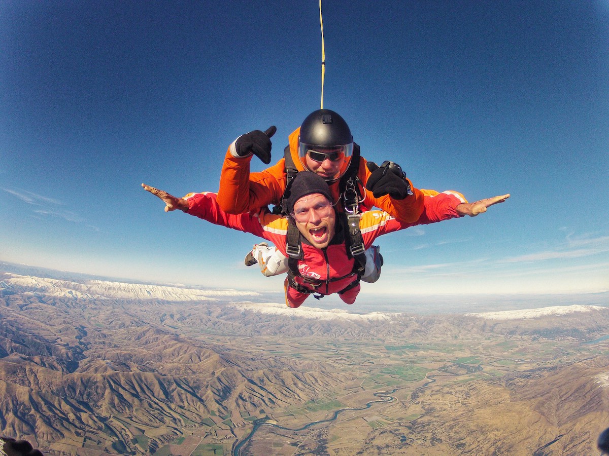 Skydiving in Wanaka Experience: My First Ever Skydive in NZ! | skydive wanaka new zealand 2 men pose for the camera during a skydive.