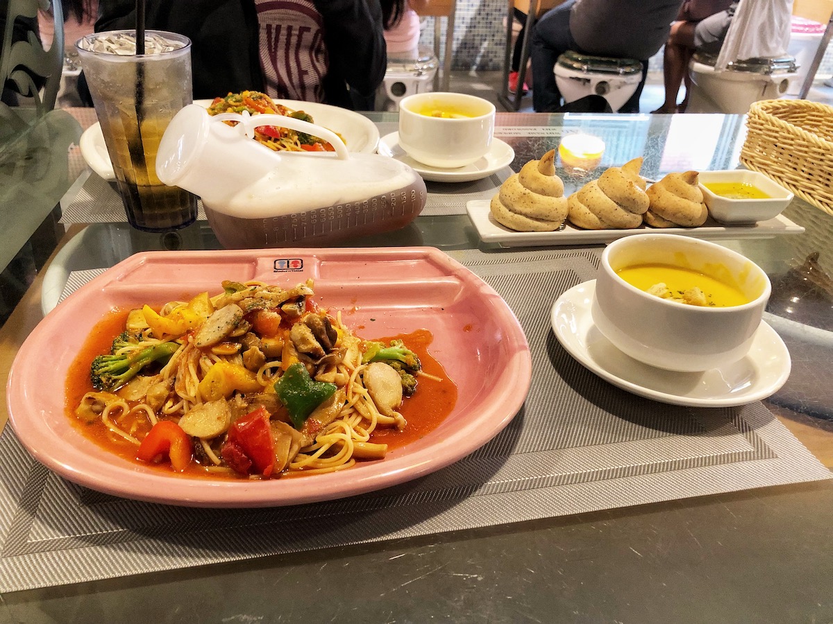 7 Unique & Fun Things To Do in Taipei (Guide For Weirdos!) | Modern Toilet Taipei food A stir fry alongside poo-shaped bread in Taipei, Taiwan