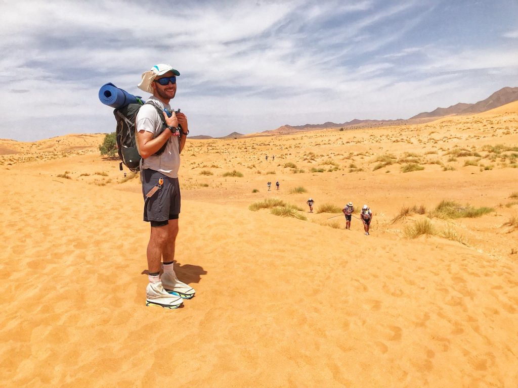 Marathon Des Sables Review: 6 Marathon/6 Days in The Sahara! | Marathon Des Sables experience Man posing in the desert with sport gear