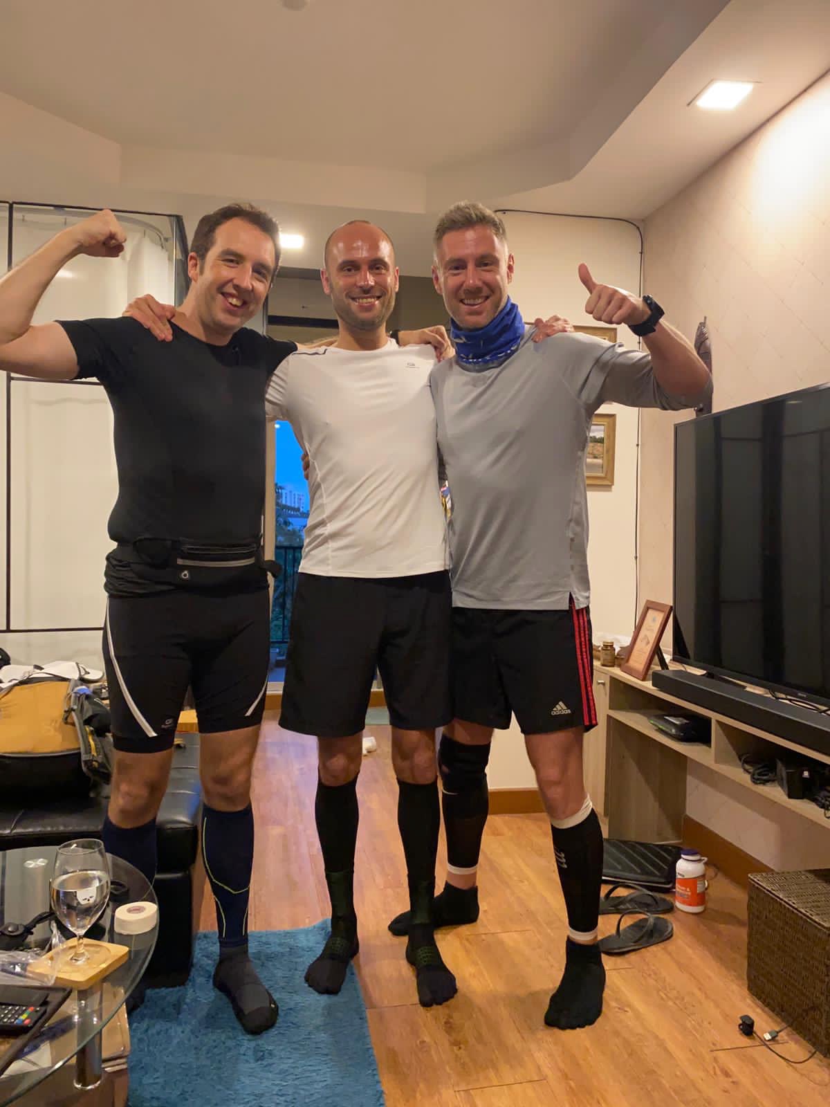 How To Run a 100 Miles Ultramarathon (And How I Did It) 2 3 men in running gear posing in a small living room