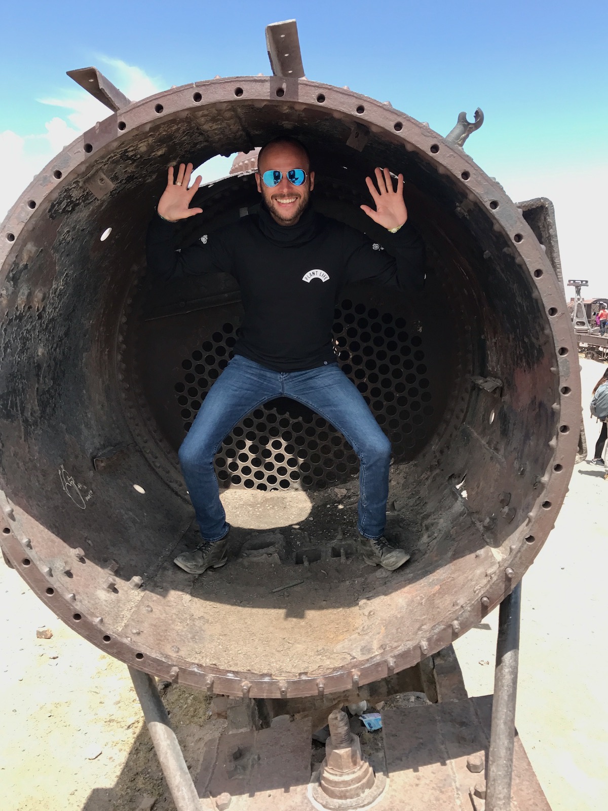 Visiting Salar de Uyuni in Bolivia: All You Need To Know | graveyard train bolivia A male tourist poses inside an old train while visiting Salar de Uyuni in Bolivia.