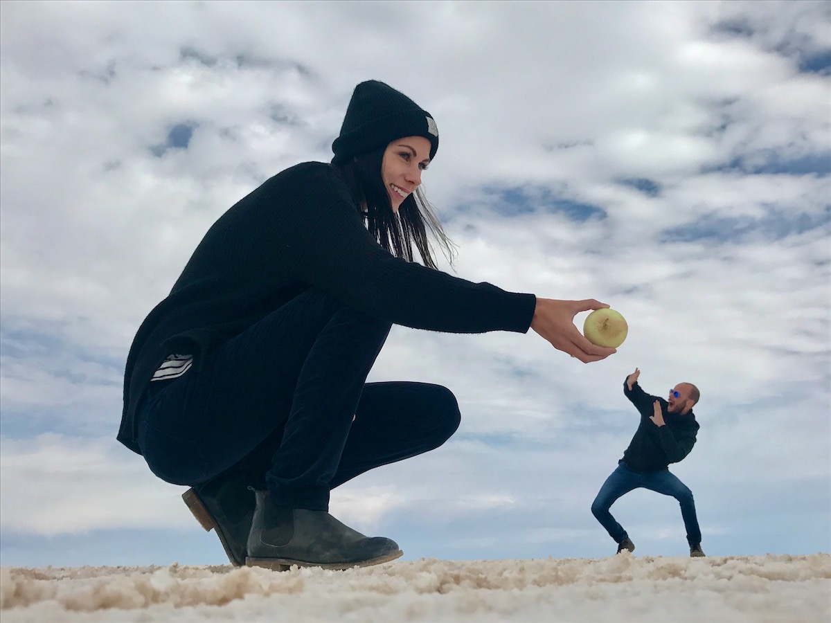 Visiting Salar de Uyuni in Bolivia: All You Need To Know | salar de uyuni bolivian salt flats funny photo A giant lady offers a disturned man an onion in Salar de Uyuni, Bolivia.