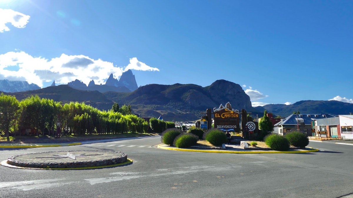 3 Weeks Patagonia Itinerary For Argentina & Chile | El Chalten Argentina Green trees near a mountain with El Chalten sign on a roundabout in Argentina