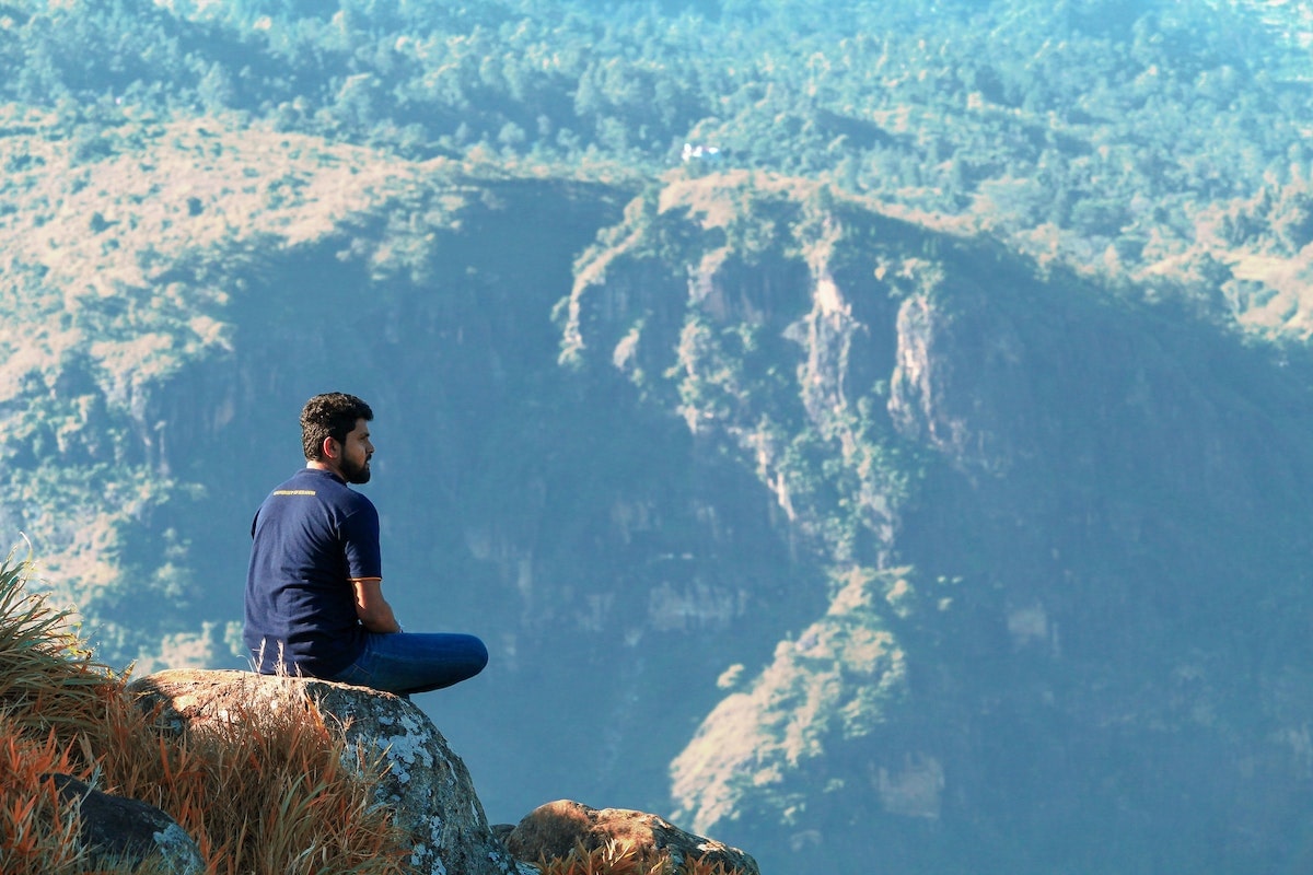 2 Weeks in Sri Lanka Itinerary For First-Timers | Little Adams peak Man sitting on top of Adam's Peak in Sri Lanka, overlooking a beautiful view