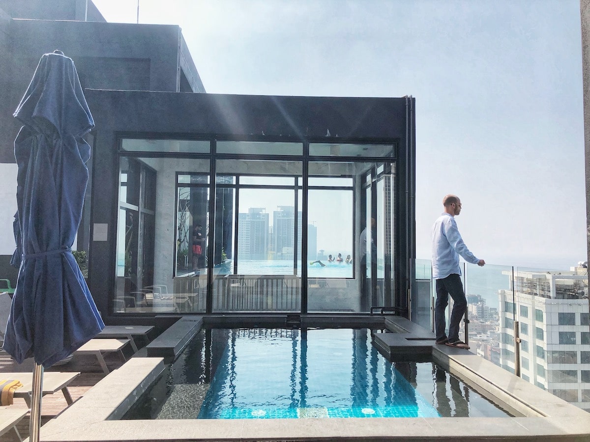 2 Weeks in Sri Lanka Itinerary For First-Timers | rooftop pool hotel Colombo Sri Lanka Man standing at pool while overlooking the Sri Lanka's capital