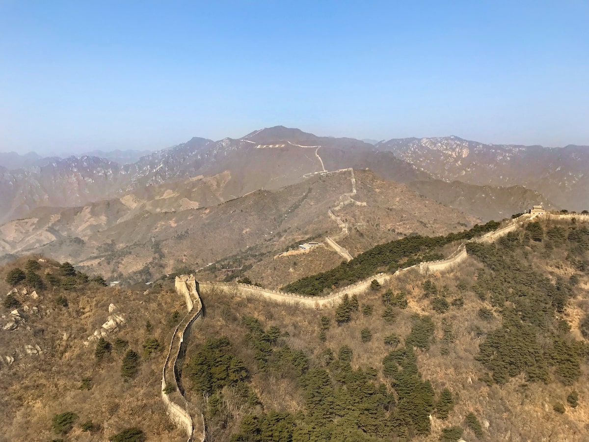 Best Place To See Great Wall of China (No Crowds, No Worries!) | How long is the great wall of china Landscape view of the mountains of the Great Wall of China on a clear day.