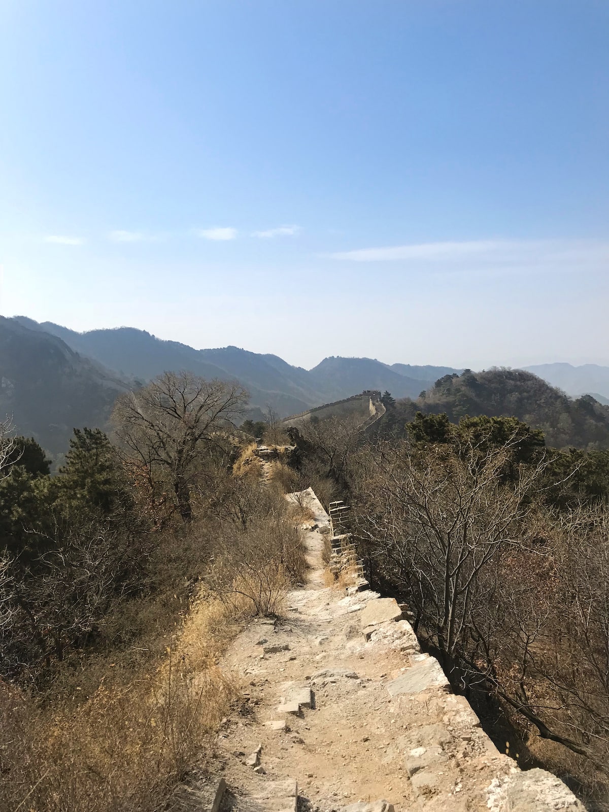 Best Place To See Great Wall of China (No Crowds, No Worries!) | Mutiyanyu Great Wall of China Broken pars of a long wall in China, with trees and mountains on either side.