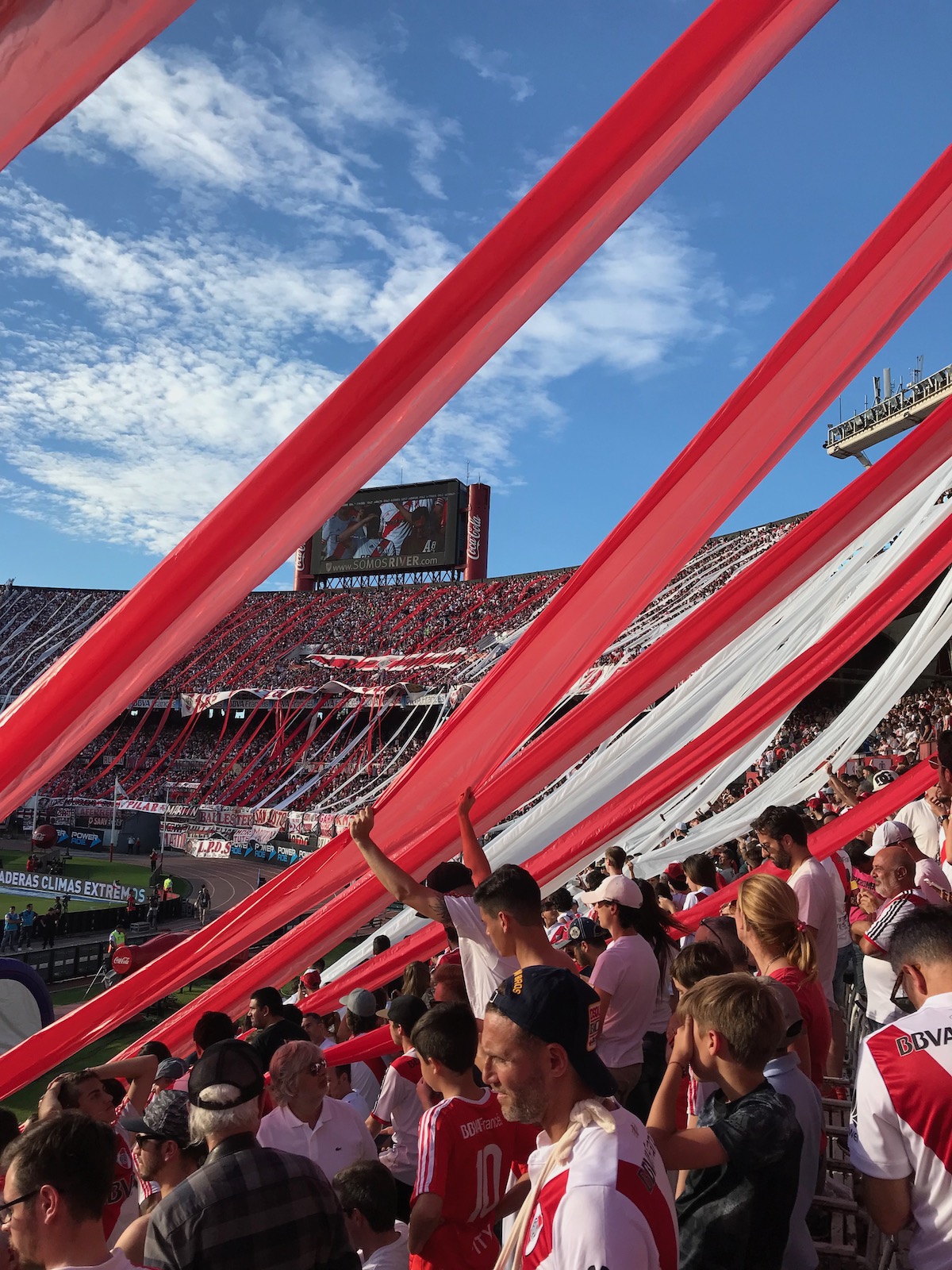 How To Buy Boca Juniors Tickets As A Tourist + Superclasico! | River Plate fans red and white flares Red and white flares dangle below football fans in a packed stadium in Buenos Aires