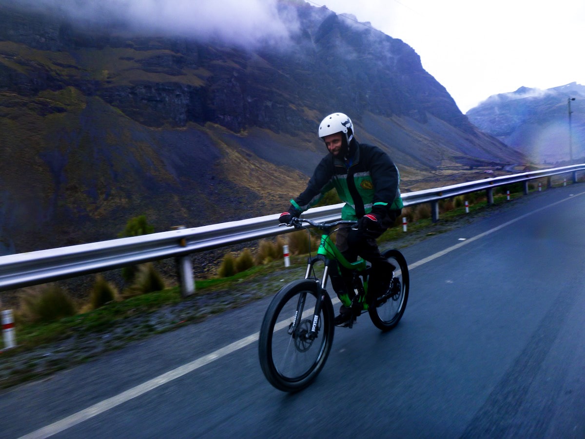Cycling Down Bolivia's Death Road (How Not To Die!) | cycling yungas road Tourist smiles in green close while cycling down the Death Road in Bolivia.