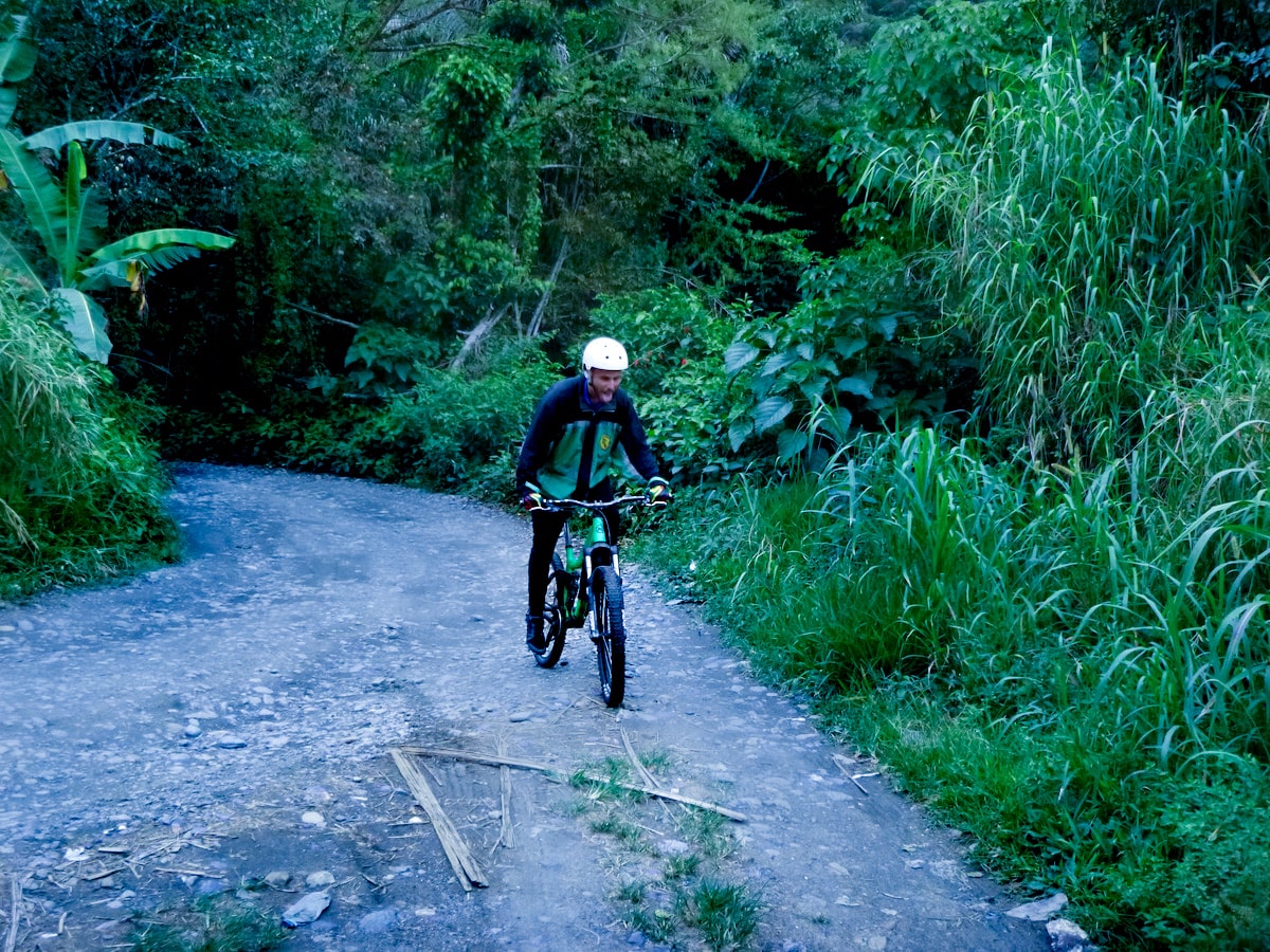 Cycling Down Bolivia's Death Road (How Not To Die!) | death road bolivia mountain bike A male tourist in green smiles as he finishes the cycle down Bolivia's Death Road.