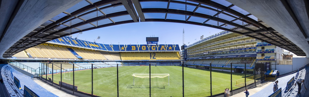 How To Buy Boca Juniors Tickets As A Tourist + Superclasico! | la bombonera An empty football stadium in Buenos Aires, with the words "Boca 12" on the seats.