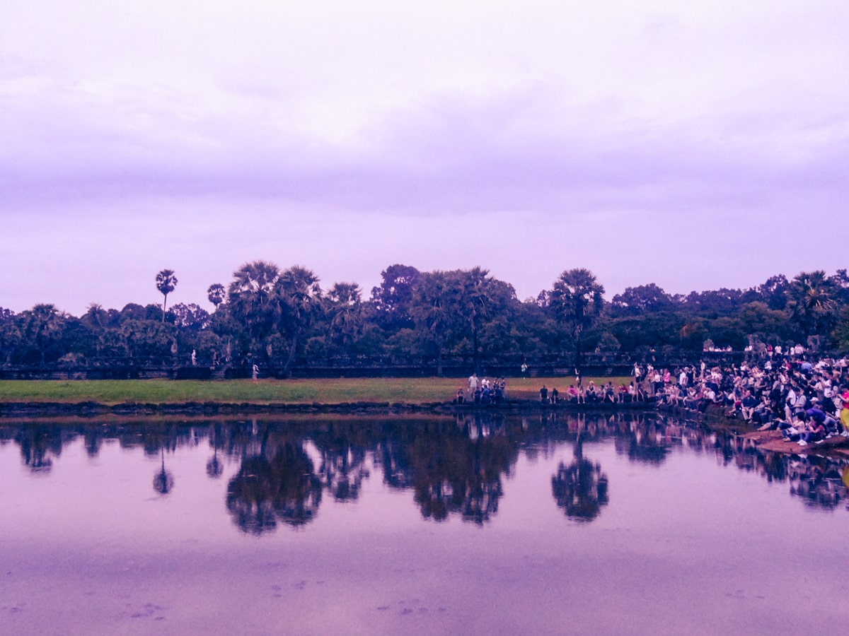 Visiting Angkor Wat: How To Avoid The Crowds | Angkor Wat before sunrise A crowd of tourists wait for sunrise at Angkor Wat in Cambodia