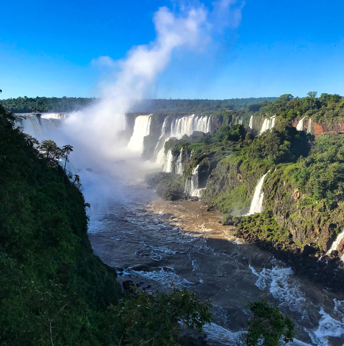 The Ultimate Guide To Visiting Both Sides of Iguazu Falls | Brazil Iguazu Falls The landscape of waterfalls on a clear blue sky day