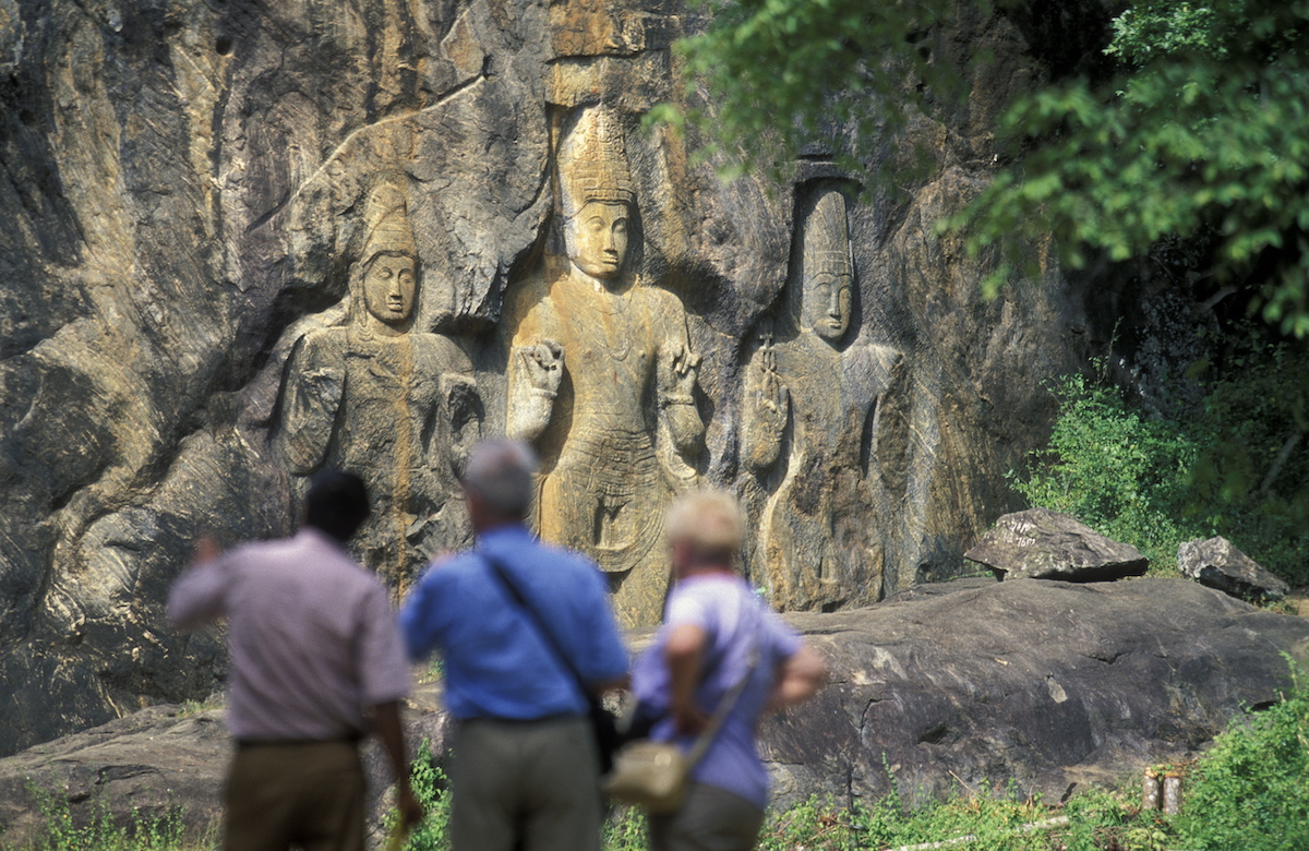 2 Weeks in Sri Lanka Itinerary For First-Timers | Buduruwagala Buddha Tourists look at large ancient carvings in Sri Lanka.