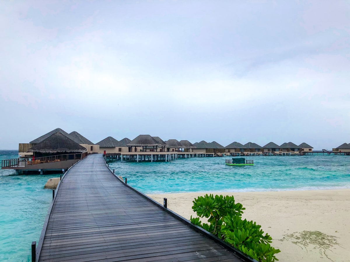 How To Plan a Trip To The Maldives | Bungalows Maldives A windy wooden walkway leading to sea bungalows in the Maldives
