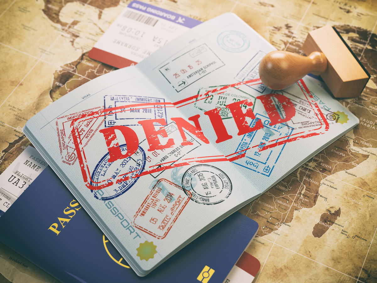 What To Do When Your ESTA is Rejected (USA Visa Waiver) | ESTA denied USA Passport with denied visa stamp on the map of the world and airline boarding pass tickets