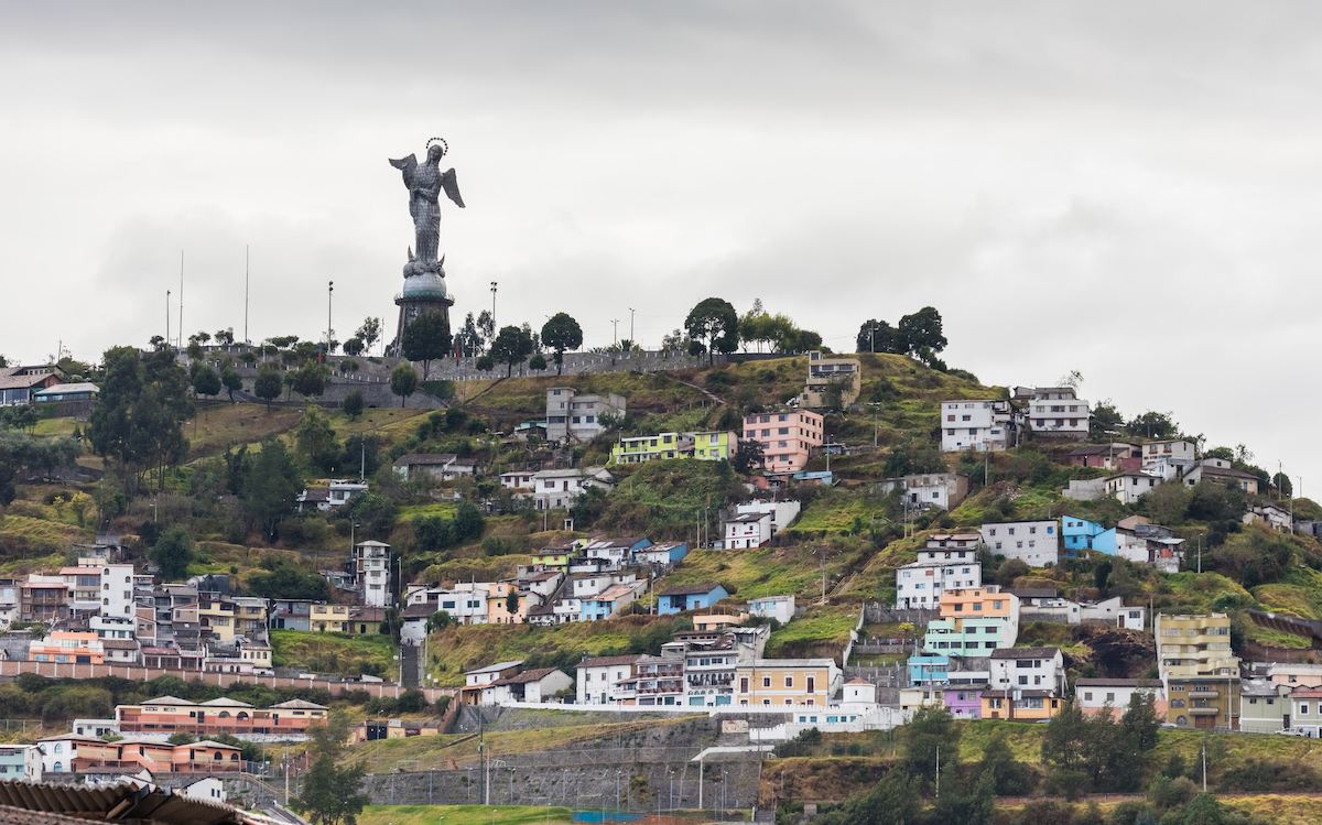 One Week in Quito, Ecuador: 23 Things in 7 Days! | El Panecillo Quito A statue of The Virgin Mary on top of a hill with coloured houses surrounding Quito, Ecuador.