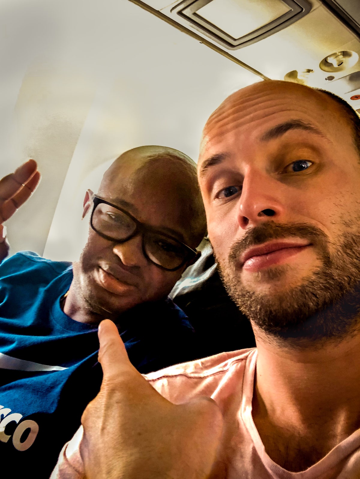 The Beginner's Guide To Climbing Mount Kilimanjaro | Flying from Arusha A white man with a beard and a black man with glasses.