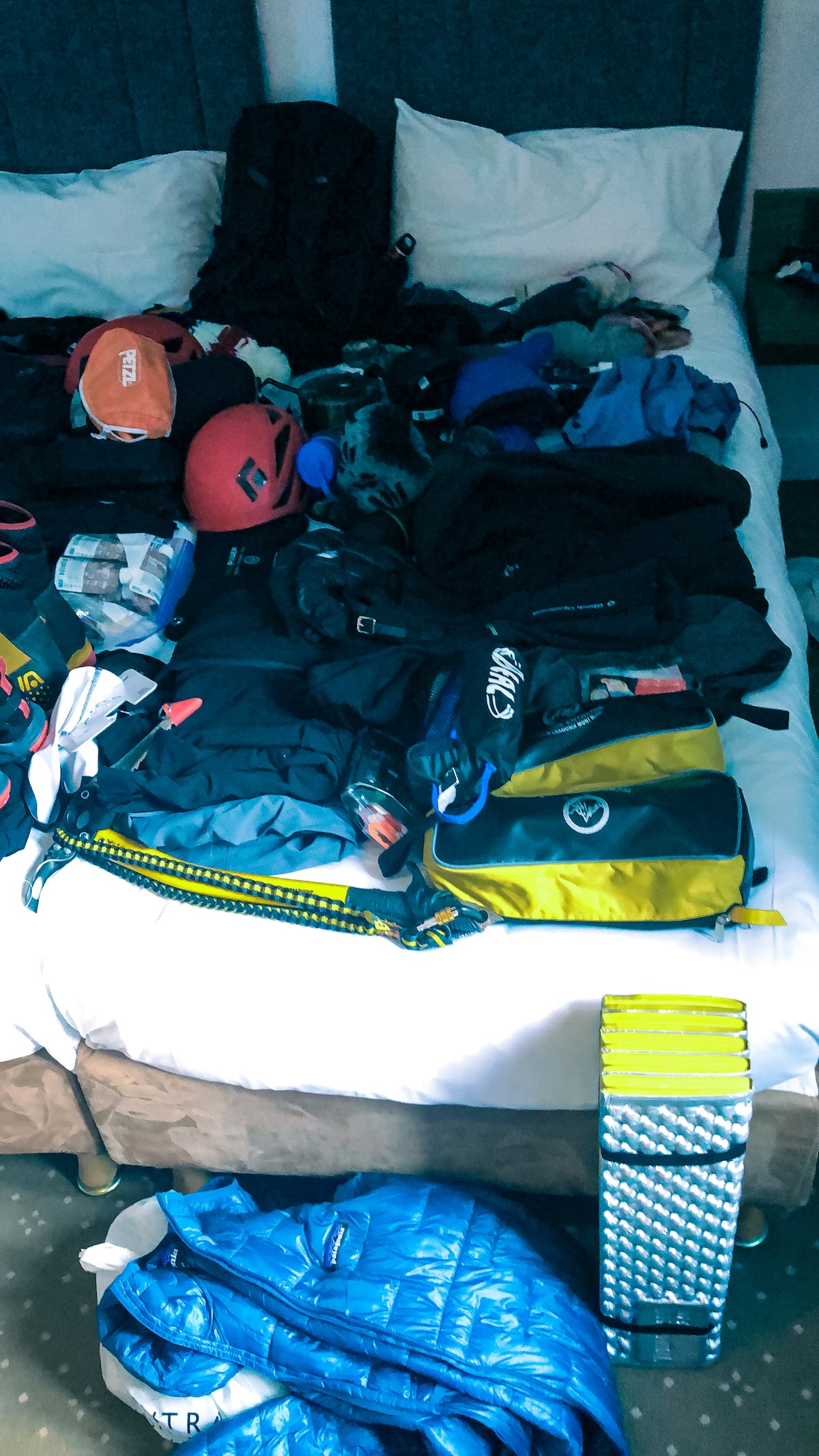Mont Blanc Climb (The Beginner's Guide To Summiting in 2024) | Gear for climbing Mont Blanc Mountain equipment is laid out on a hotel bed.