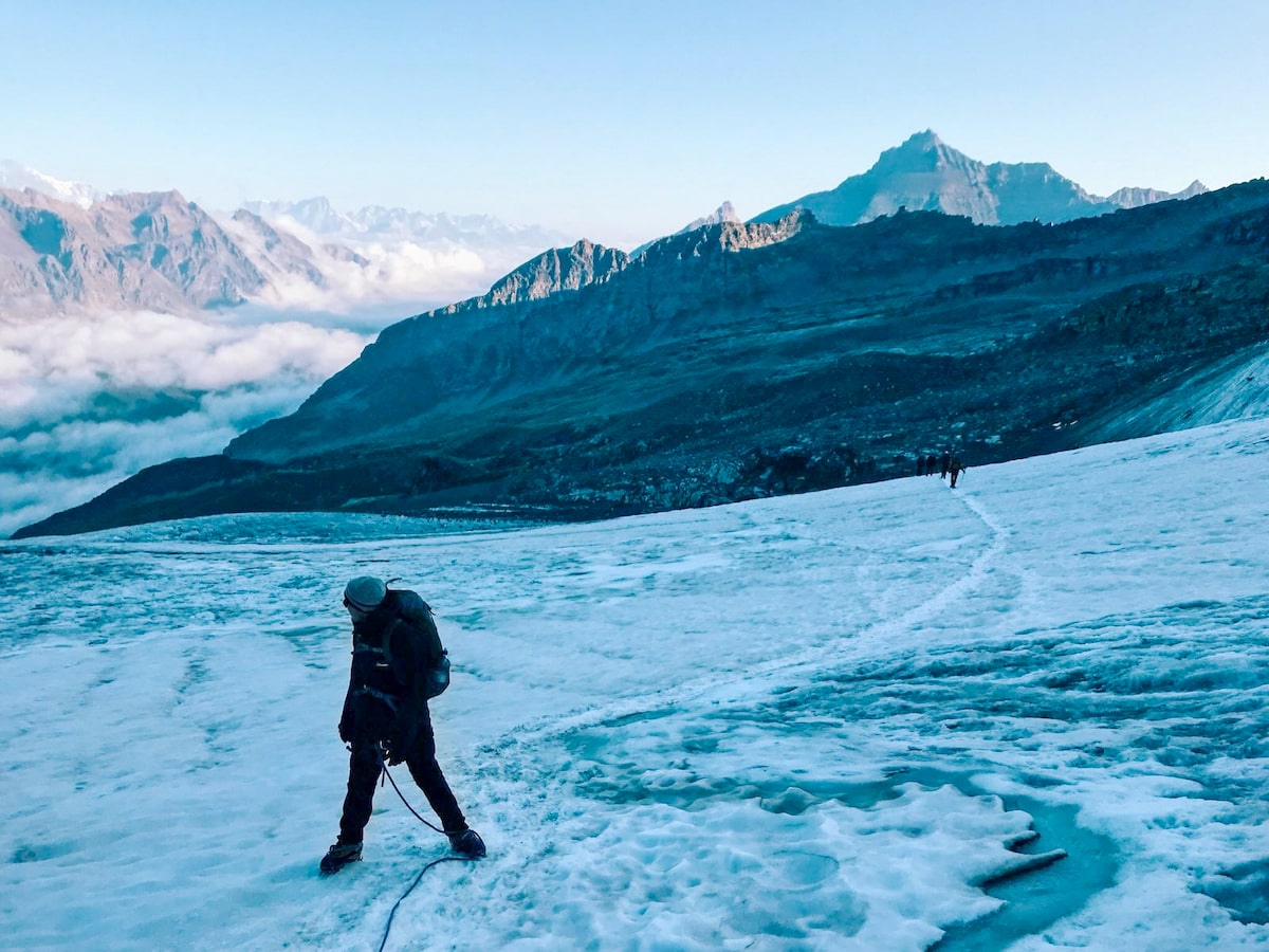 Mont Blanc Climb (The Beginner's Guide To Summiting in 2024) | Glacier Mont Blanc A climber looks up into the French Alps as the rest of the tour walk to join him on the ice.