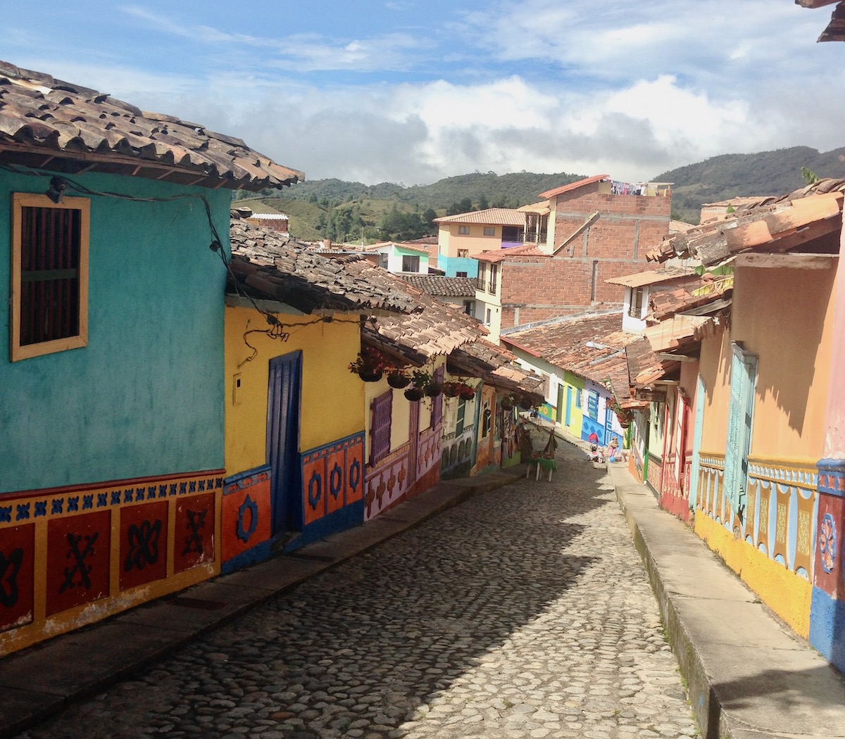 13 Brilliant Weekend & Day Trips From Medellin | Guatape day trip from Medellin Colourful houses on a cobblestone path on a sunny day in Guatape, a popular day trip from Medellin in Colombia