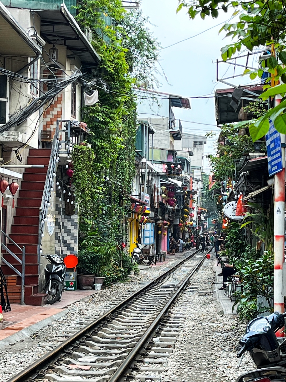 One Day in Hanoi Itinerary: No Transport Needed (Walking Only!) | Hanoi Train Street A train track runs through a busy street in Hanoi, Vietnam