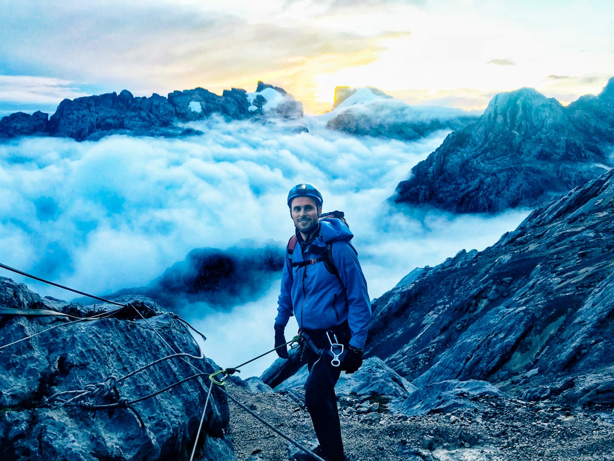 Climbing Puncak Jaya: How To Summit Carstensz Pyramid | Harrers Route Puncak Jaya A climber in blue standing above the clouds while climbing Puncak Jaya