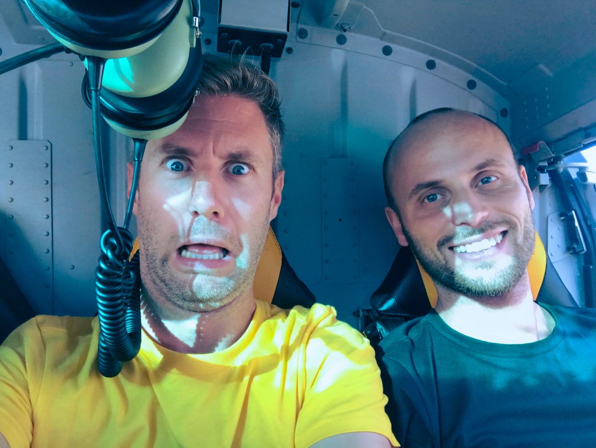 Climbing Puncak Jaya: How To Summit Carstensz Pyramid | Inside helicopter Two men pose inside a helicopter en route to climbing Puncak Jaya in West Papua, Indonesia