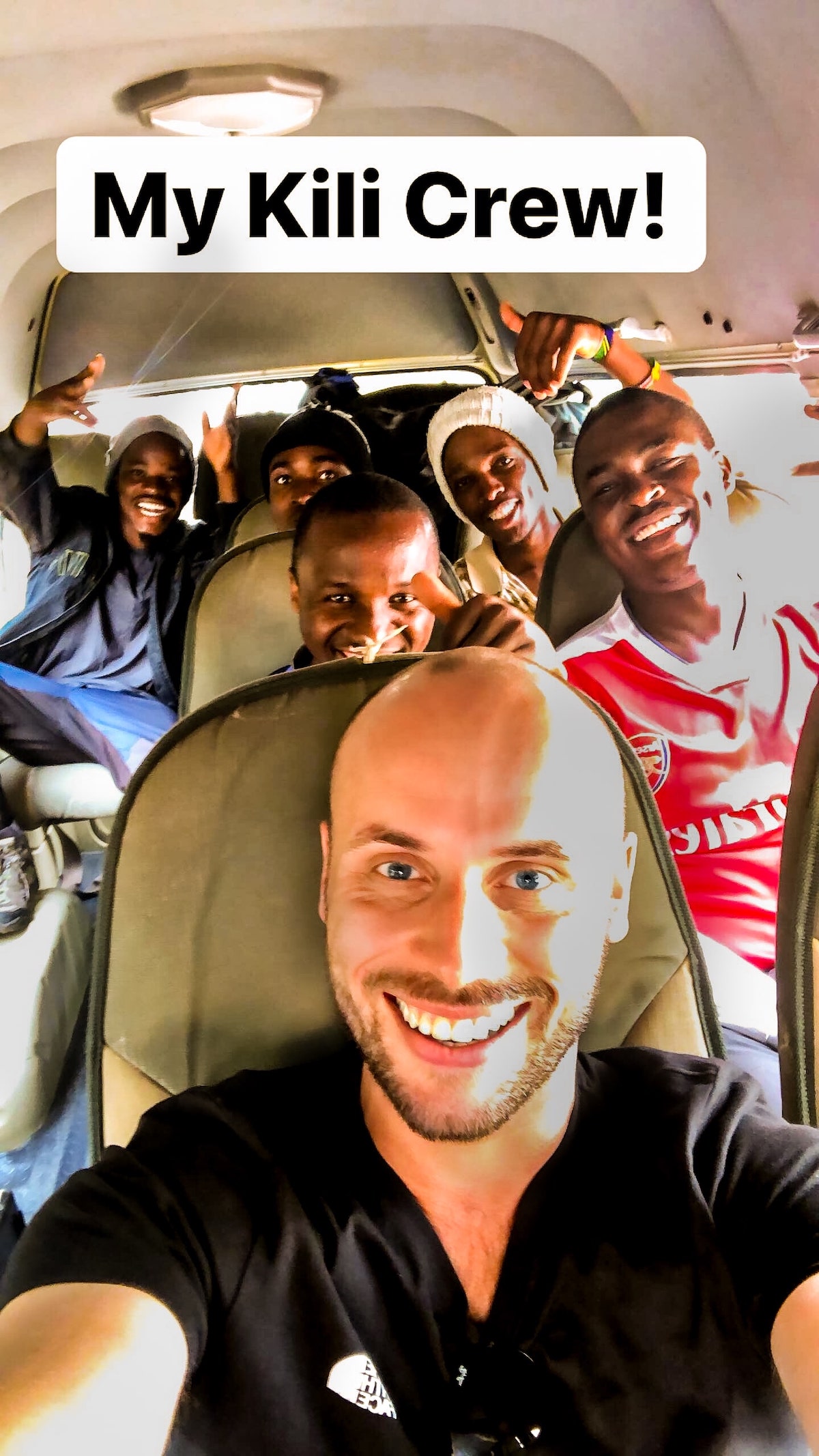 The Beginner's Guide To Climbing Mount Kilimanjaro | Kilimanjaro tour team A group of men smile for a selfie photo inside a van.
