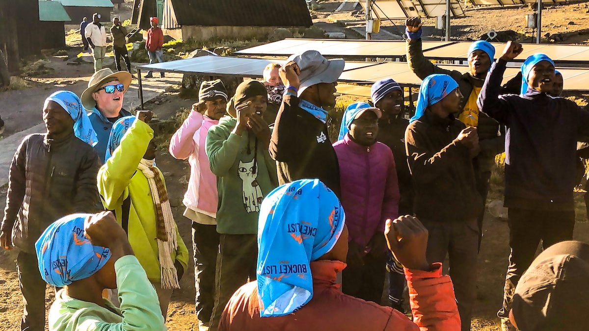 The Beginner's Guide To Climbing Mount Kilimanjaro | Local guides singing on Kilimanjaro A group of Africans sing and dance on Mount Kilimanjaro.