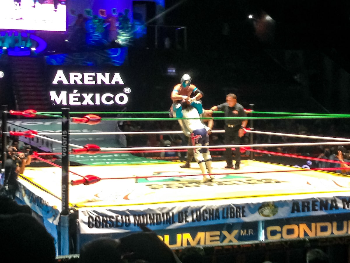 16 Famous Landmarks in Mexico (& How To See Them in 2024!) | Lucha Libre Mexico City A wrestler picks up a masked wrestler in a wrestling ring in a packed arena, in Mexico City.