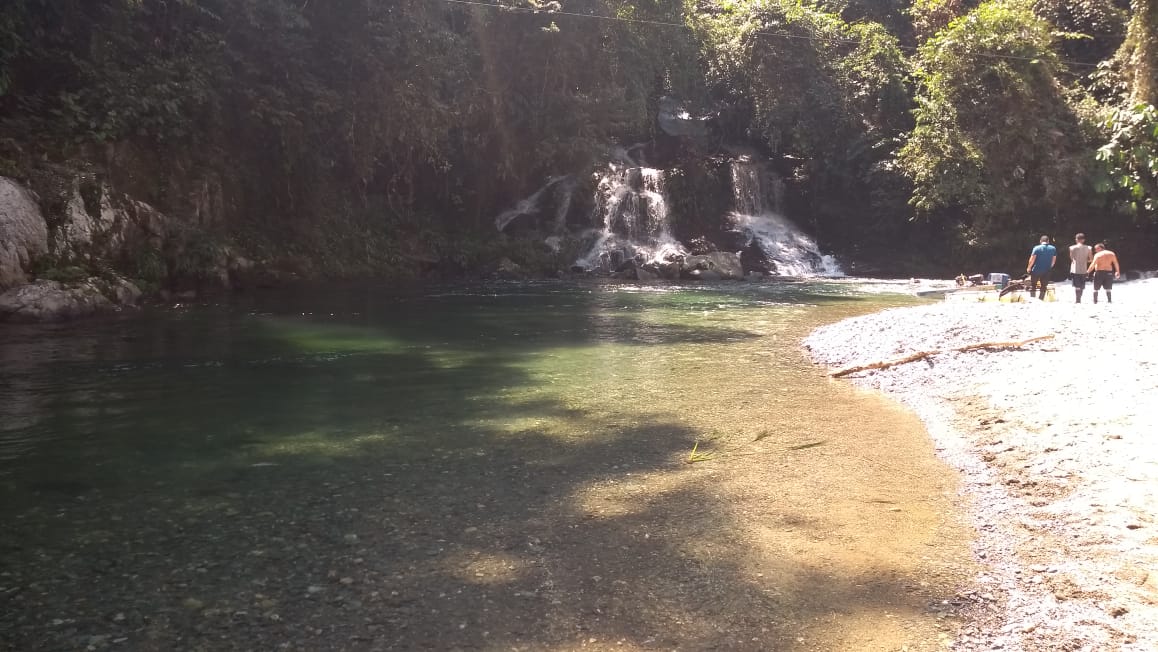 13 Brilliant Weekend & Day Trips From Medellin | Melcocho River Colombia A group walk past an emerald river