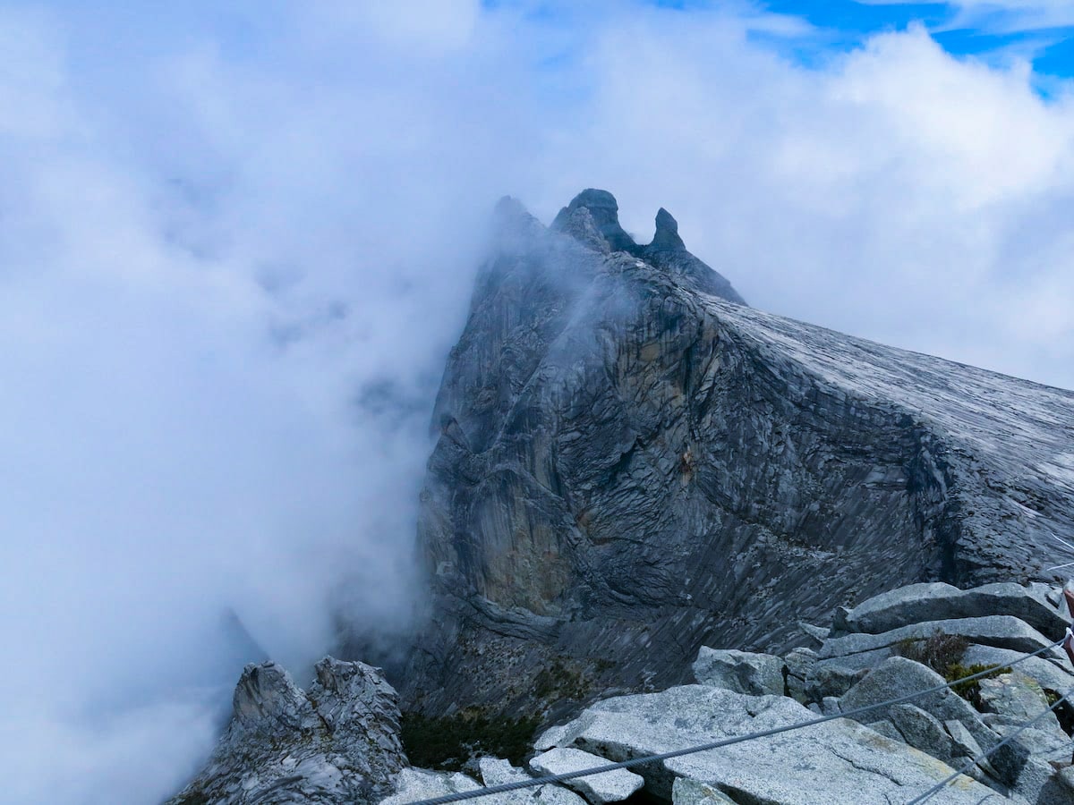 Climbing Mount Kinabalu Tips & Info For First-TimersĀ | Mount Kinabalu climb A mountain peak escaping into the clouds.