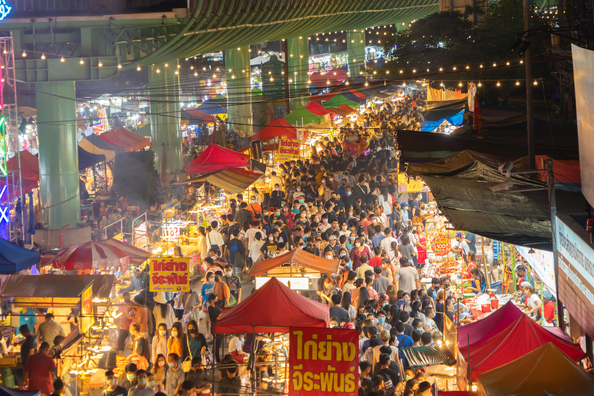 The 10 Best Neighborhoods For Expats in Bangkok | Ratchada night market Night Market people walking street fair, Colorful tents in the train of Ratchada at Bangkok city, Thailand. Retail shops