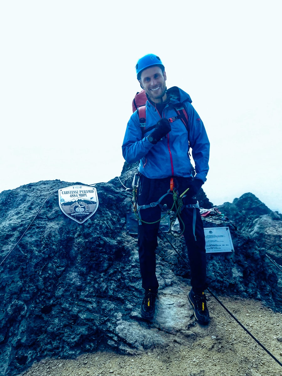 Climbing Puncak Jaya: How To Summit Carstensz Pyramid | Summit Puncak Jaya Carstensz Pyramid A man smiles as he reaches the summit of Puncak Jaya