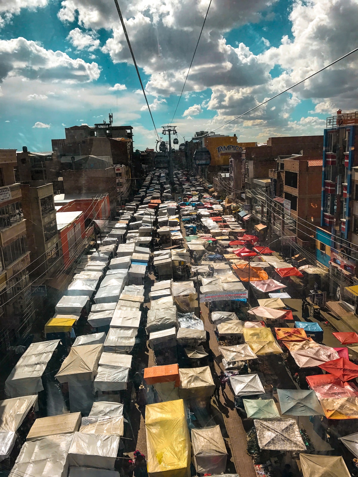 28 Best Things To Do in La Paz, Bolivia & Surrounding Areas | Teleferico Tour La Paz Bolivia A bird's eye view of a large marketplace from a teleferico (cable car) in La Paz, Bolivia.
