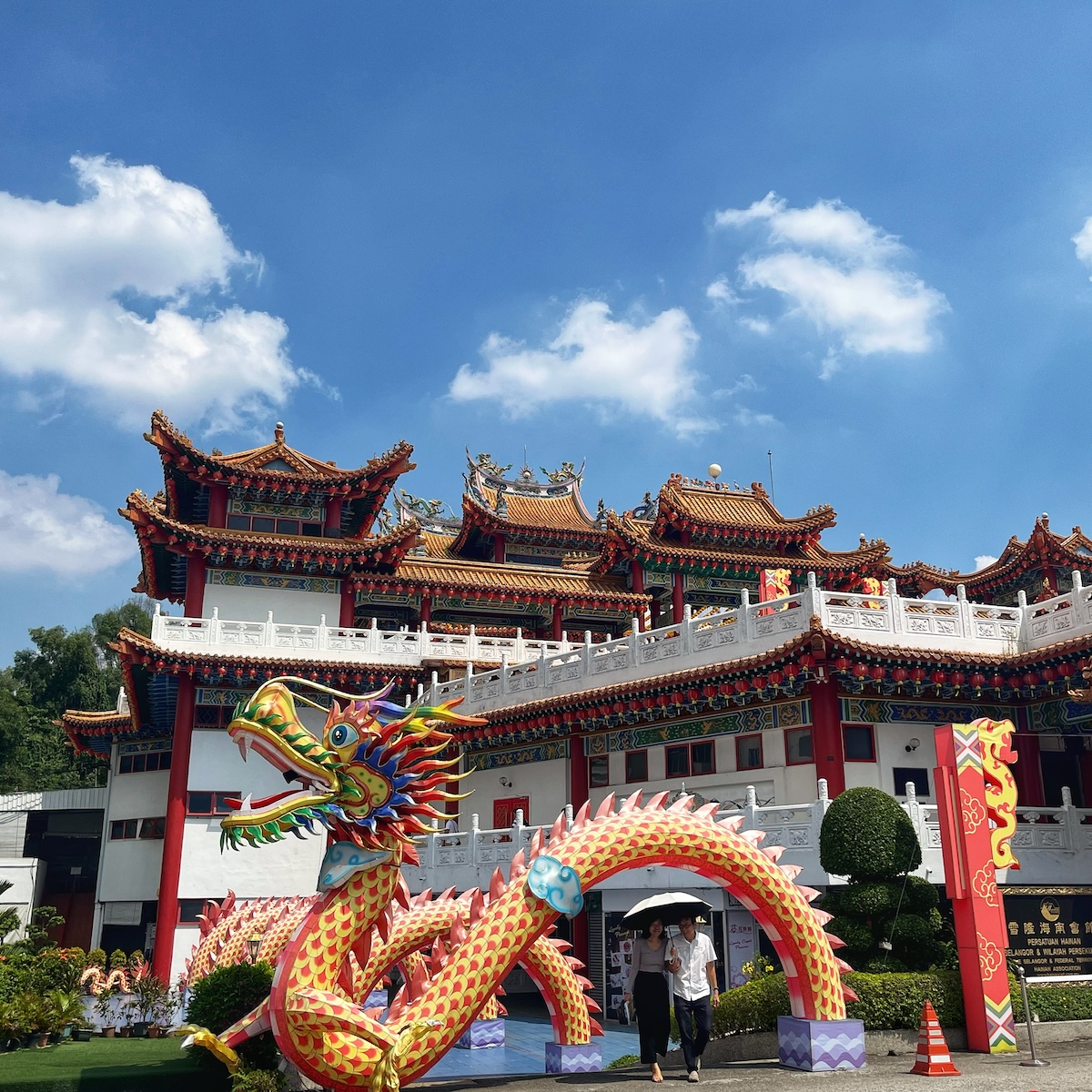 How Many Days Should You Spend in Kuala Lumpur? | Thean Hou Temple Colorful dragon sculpture and the ornate architecture of Thean Hou Temple in Kuala Lumpur, Malaysia, under a clear blue sky with a few clouds. Visitors are walking near the entrance, highlighting the temple's vibrant design and traditional Chinese elements.