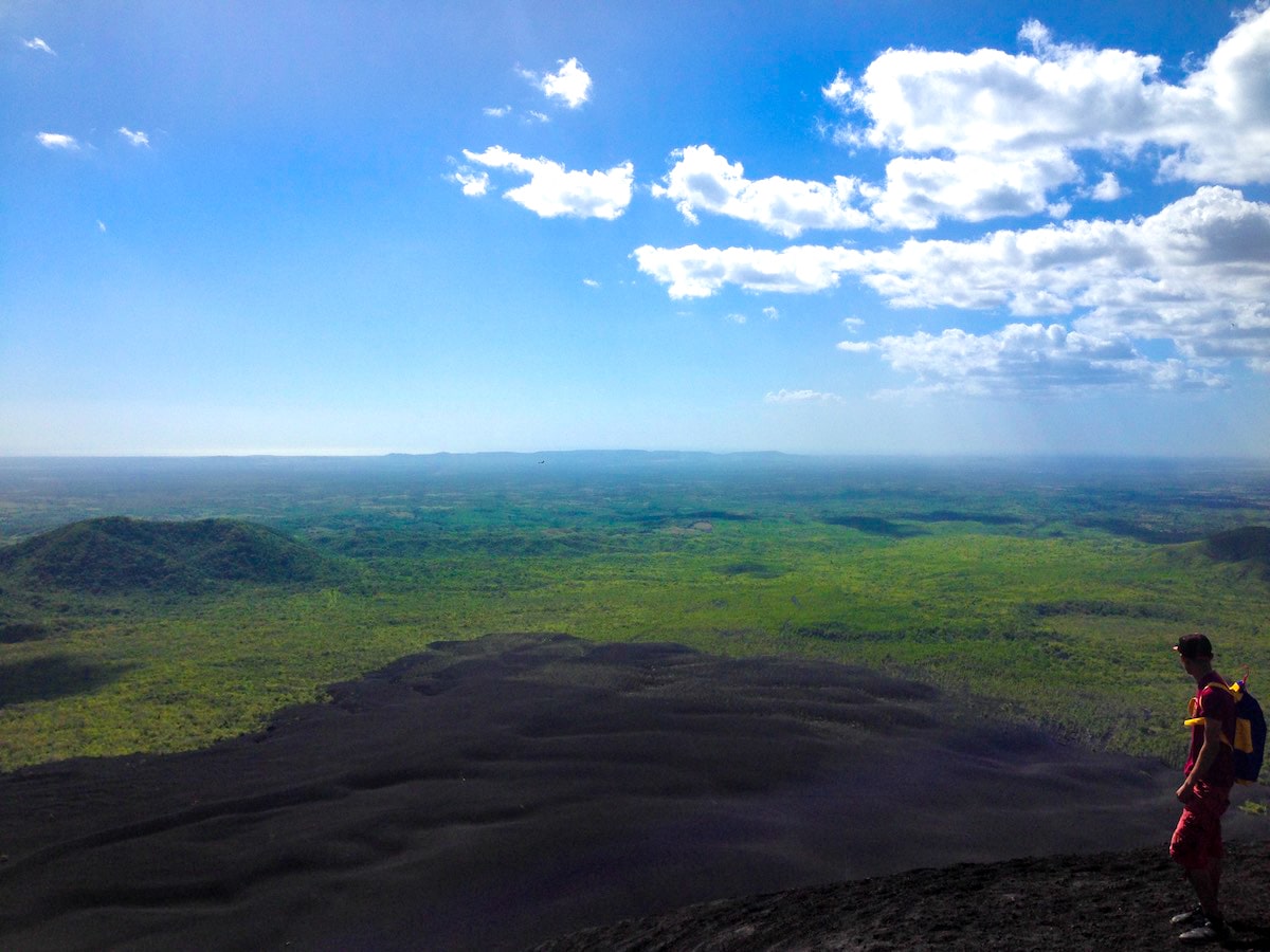 Volcano in Boarding in Leon, Nicaragua (Cerro Negro) | Top of Cerro Nicaragua A man looks out into the horizon from the top of a volcano in Nicaragua.