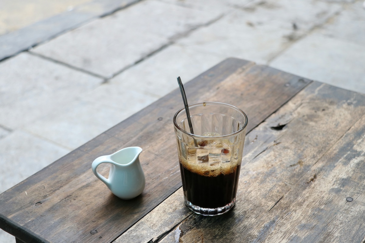 One Day in Hanoi Itinerary: No Transport Needed (Walking Only!) | Vietnam coffee Vietnamese iced coffee on a wooden table with a small white jug