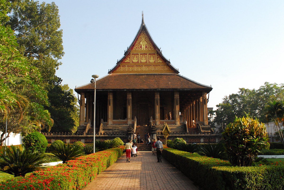 15 Things To Do in Vientiane, Laos (Includes Day Trips) | Wat Ho Phra Keo People attend a golden temple in Laos