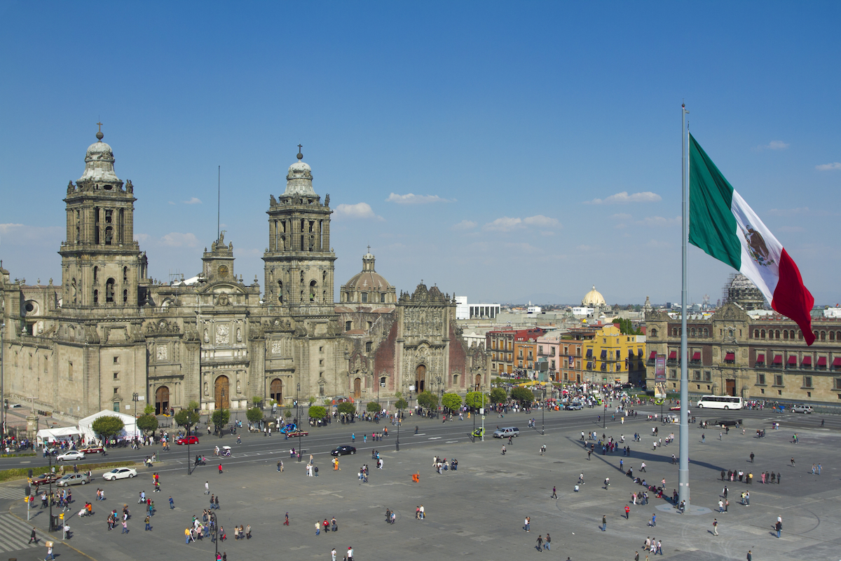 Detailed Digital Nomad Mexico City Guide For 2024 | Zocalo Plaza Mexico City A plaza in Mexico City, with a cathedral and giant flag in the centre