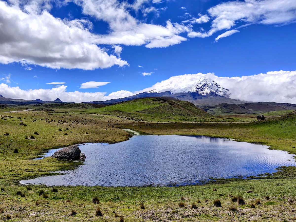 One Week in Quito, Ecuador: 23 Things in 7 Days! | antisano volcano A frosted mountain in the distance of a large green plain in Ecuador.