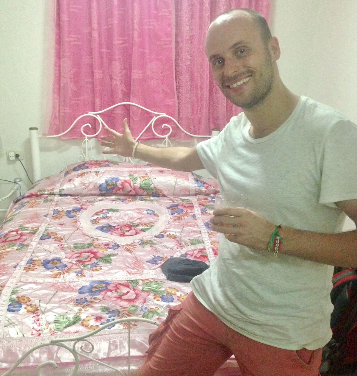 The Only Road Trip Packing List You'll Ever Need! | casa particular Havana Cuba A man smiles goofily in a pink bedroom in a Casa Particular in Havana, Cuba