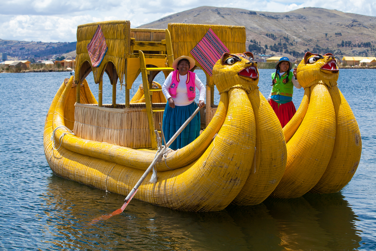 28 Best Things To Do in La Paz, Bolivia & Surrounding Areas | cholita lake titicaca A women in traditional dress smiles on a local boat in Lake Titicaca