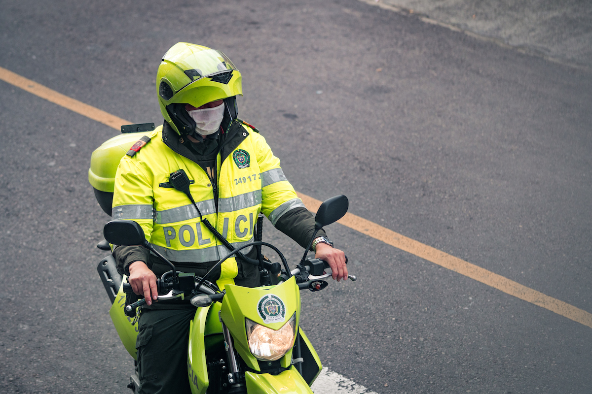 7 Things To Know Before Living in Medellin, Colombia | colombian policeman A Colombian policeman on a motorbike wearing a mask.