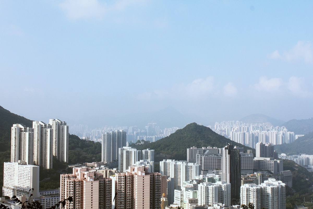 The Ultimate Hong Kong Bucket List: 25 Best Things To Do! | dragons back trail hong kong A large hill towers above skyscrapers in Hong Kong