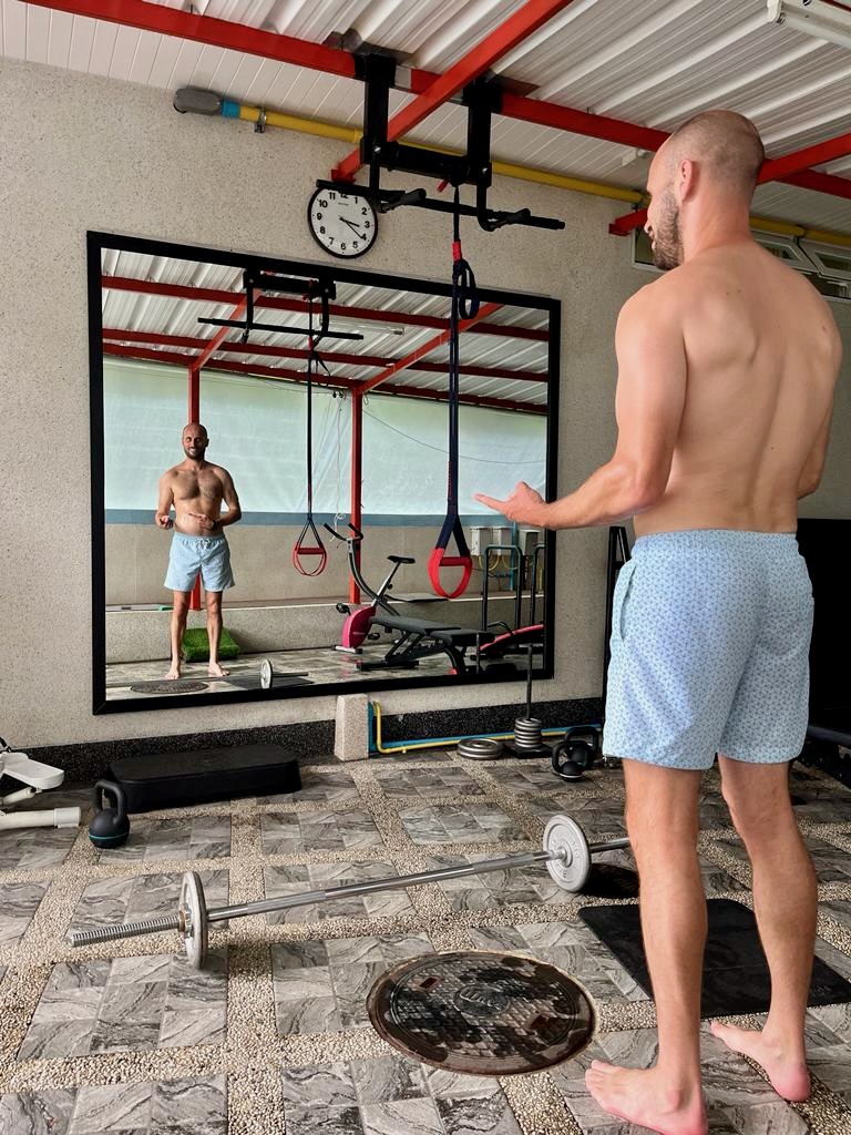 2023 Review: Turning 40, Feeling Good & Plans For 2024 | gym shot Man looks at himself shirtless in the mirror
